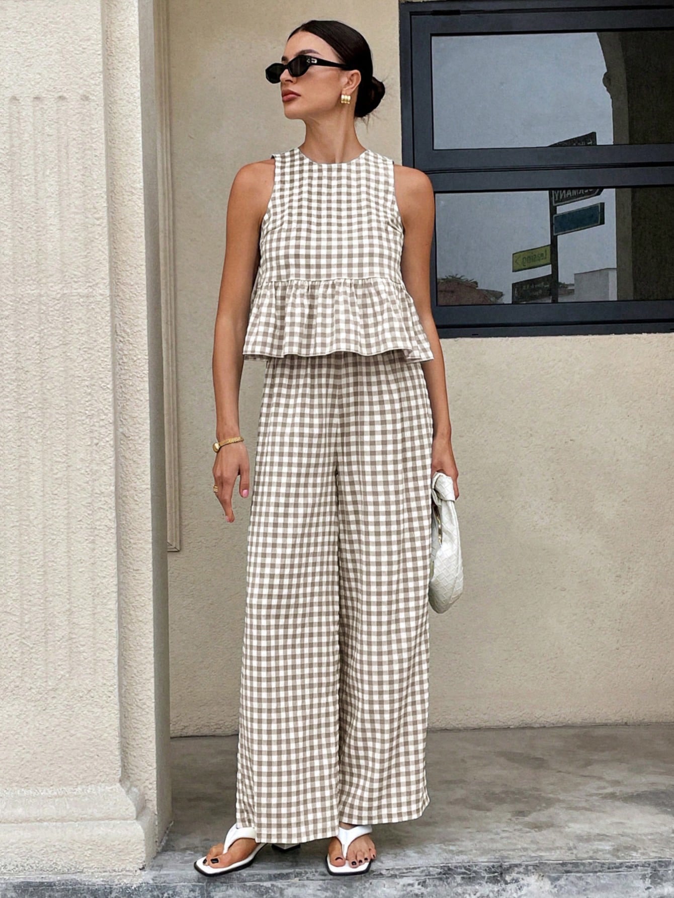Top informal de cuello redondo sin mangas para mujer con bajo con volantes y pantalones de pierna recta.