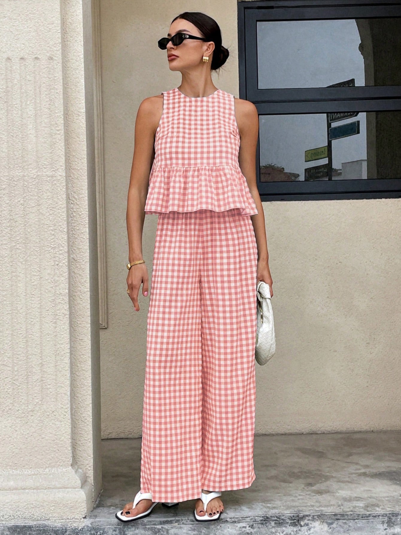 Top informal de cuello redondo sin mangas para mujer con bajo con volantes y pantalones de pierna recta.